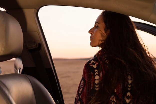 Back view of woman getting out of car to enjoy nature