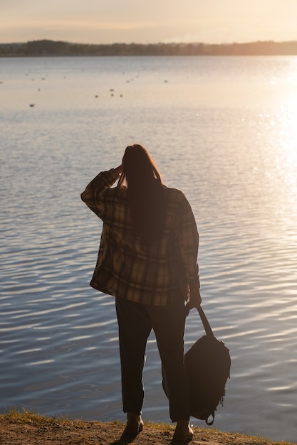 Free photo back view woman holding backpack