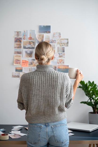 Free photo back view woman holding cup