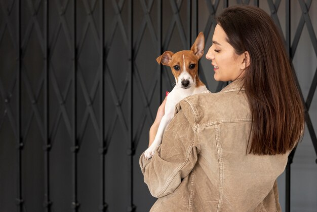 Back view of woman holding her dog outside