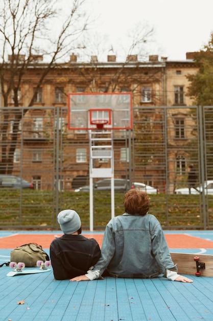 Free photo back view woman and man looking at a basketball field