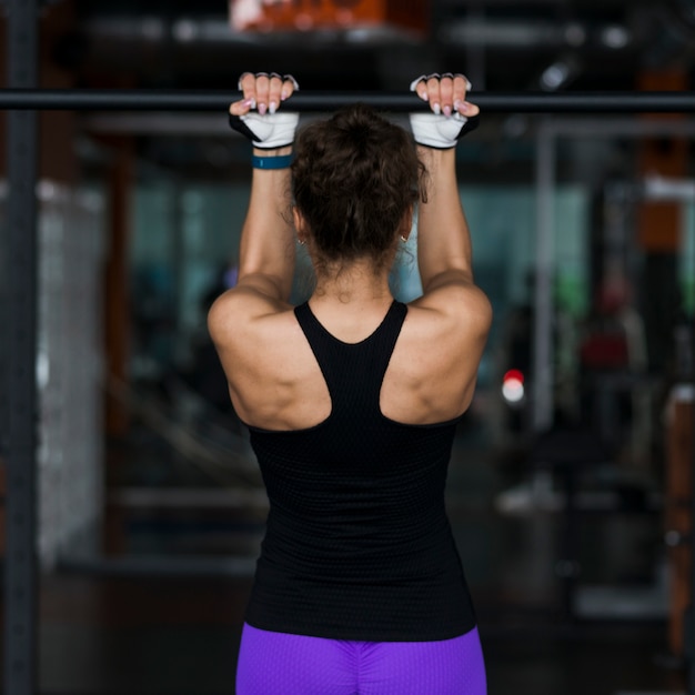 Back view woman performing pull-ups