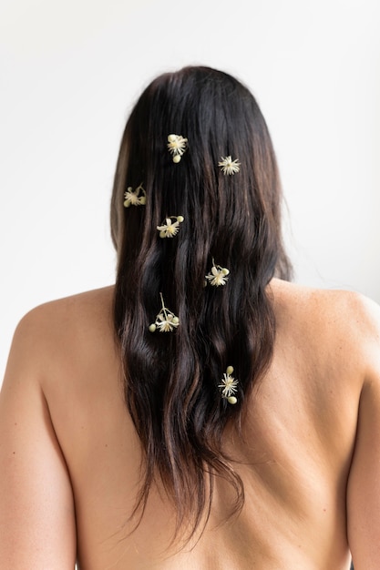 Free photo back view of woman posing naked with flowers in her hair