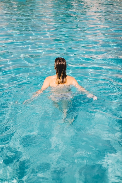 Free Photo back view of woman in swimming pool