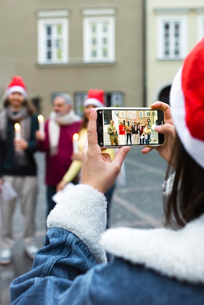 Free photo back view woman taking photos with smartphone