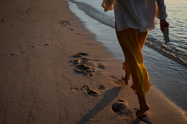 Free photo back view woman walking on the beach