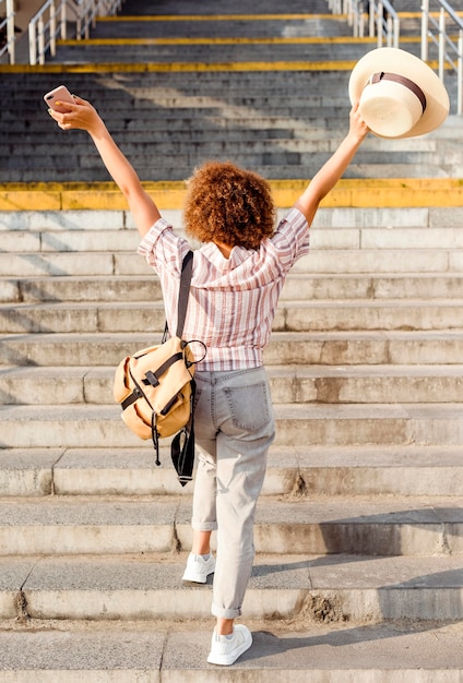 Free photo back view woman walking the stairs outdoors