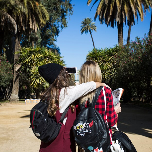 Back view women with map taking selfie