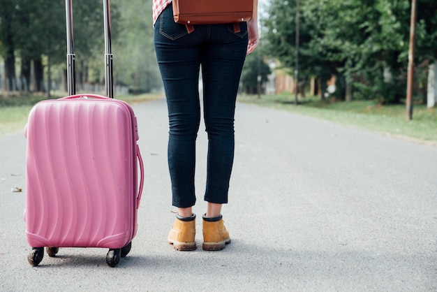 Free Photo back view young girl with pink luggage in the park