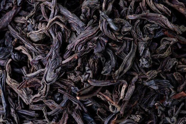 Background of dry black tea leaves texture, top view