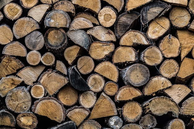 Background of stacked chopped firewood in a woodpile