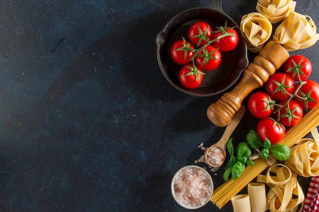 Free photo background with fresh tomatoes and variety of pasta