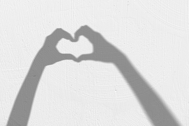 Free photo background with shadow of hands making heart sign