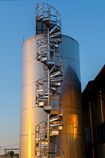 Backyard of winery at sunset with metal wine storage tanks