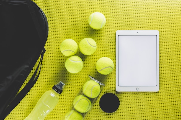 Bag near tennis balls and tablet