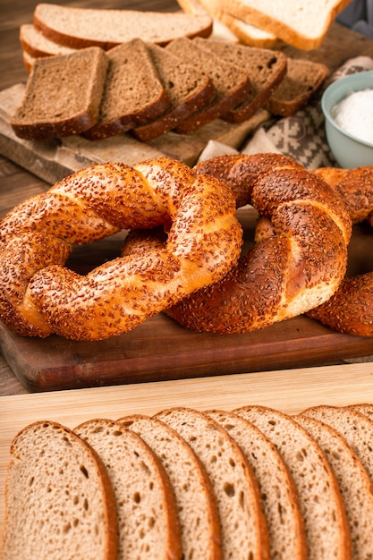 Bagel and slices of dark bread on kitchen board