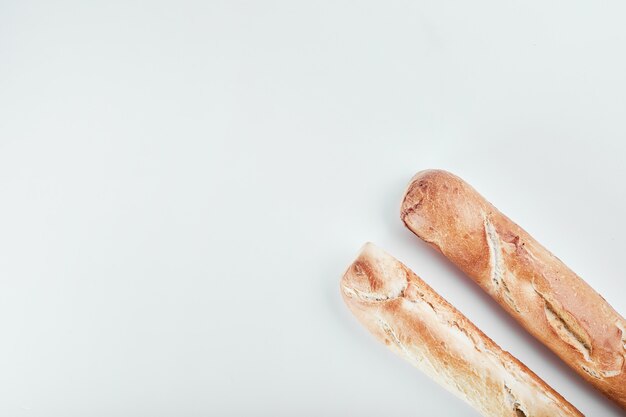 Baguette breads isolated on white table.