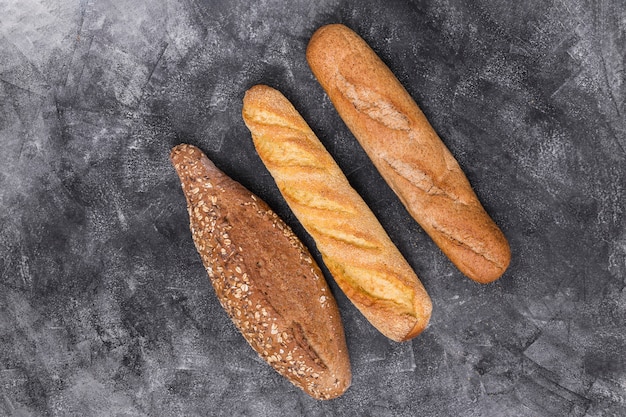 Free photo baguette and loaf on weathered backdrop