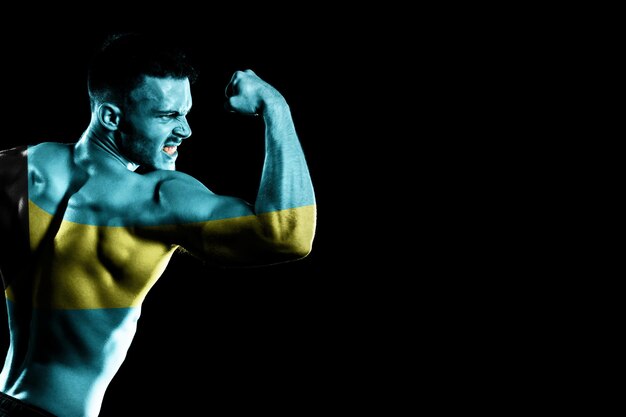 Bahamas flag on handsome young muscular man black background