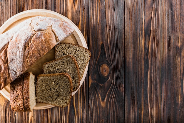 Baked bread slices on plate over the wooden background