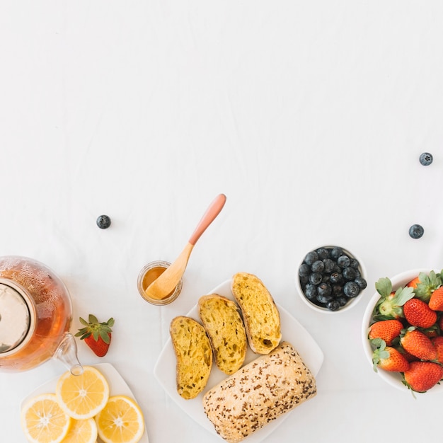 Baked bread with fresh healthy fruits on white background