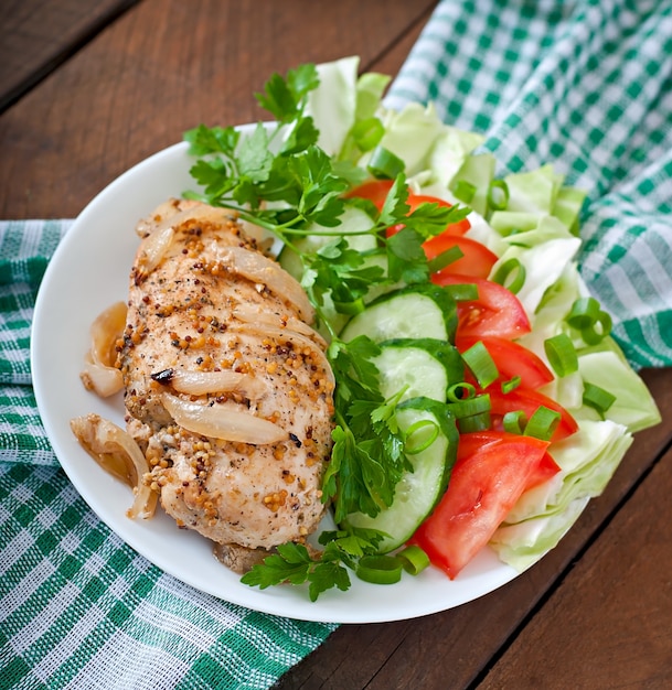 Baked chicken breast and fresh vegetables on the plate 