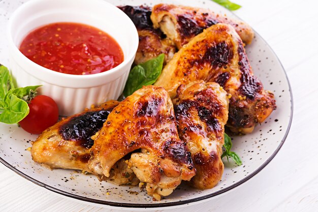 Baked chicken wings in the Asian style and tomatoes sauce on plate