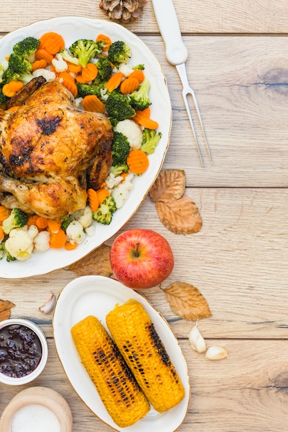 Free photo baked chicken with corns on wooden table