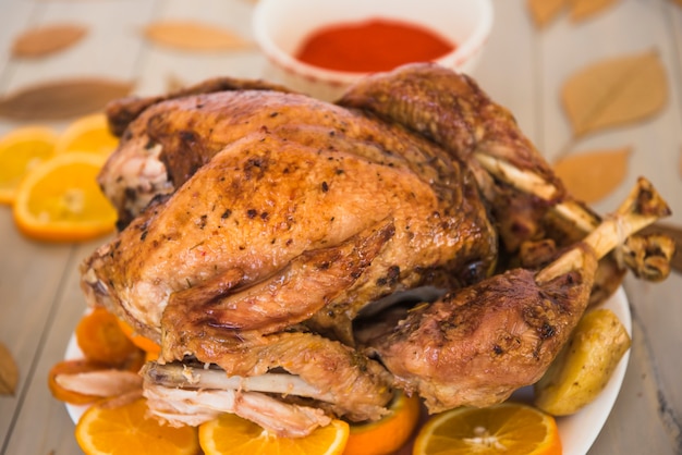 Baked chicken with oranges on white plate