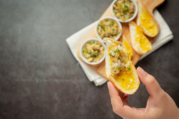 Baked clam with garlic and butter served with garlic bread on dark background