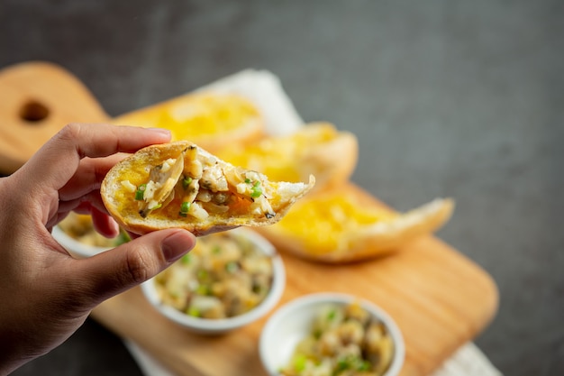 Free photo baked clam with garlic and butter served with garlic bread on dark background