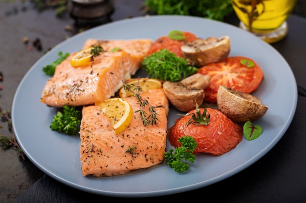 Baked salmon fish fillet with tomatoes, mushrooms and spices. Diet menu.