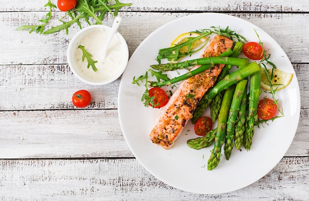 Free Photo baked salmon garnished with asparagus and tomatoes with herbs. top view