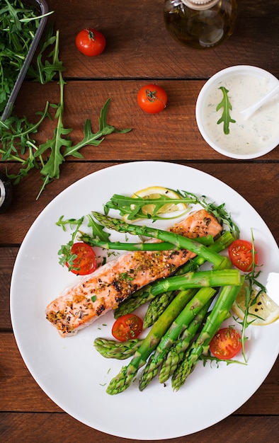 Free Photo baked salmon garnished with asparagus and tomatoes with herbs.