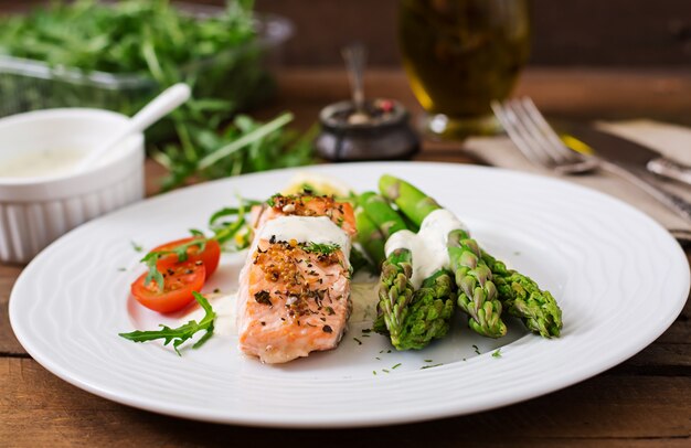 Baked salmon garnished with asparagus and tomatoes with herbs