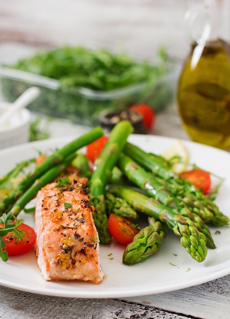 Free Photo baked salmon garnished with asparagus and tomatoes with herbs