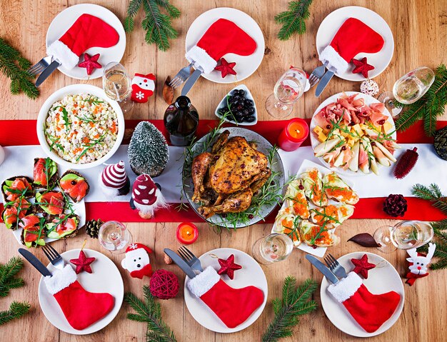 Baked turkey. Christmas dinner. The Christmas table is served with a turkey, decorated with bright tinsel and candles. Fried chicken, table.  Family dinner. Top view, flat lay, overhead, copy space