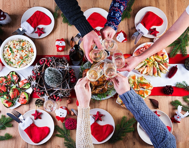 Baked turkey. Christmas dinner. The Christmas table is served with a turkey, decorated with bright tinsel and candles. Fried chicken, table.  Family dinner. Top view, hands in the frame