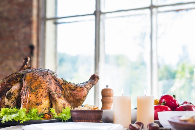 Free photo baked turkey with candles on table