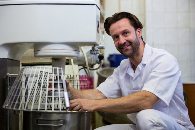 Baker adjusting dough machine