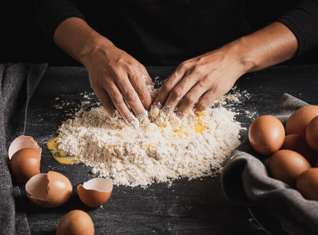 Baker hands mixing eggs with flour