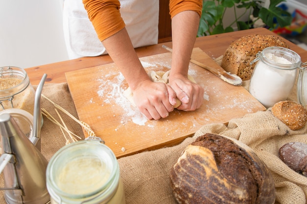 Free photo baker kneading dough for pastry on wooden board