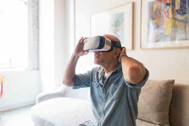 Free photo bald man enjoying vr experience at home