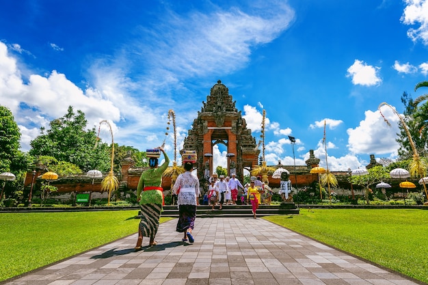 Balinese people in traditional clothes during religious ceremony at Pura Taman Ayun Temple, Bali in Indonesia