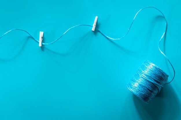 A ball of blue threads on a blue background flat lay