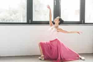 Free photo ballerina dancer dancing near the window