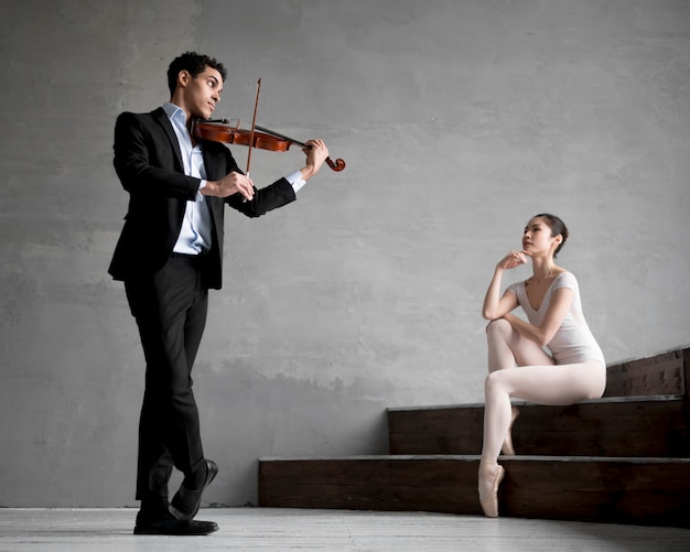 Free Photo ballerina listening to musician playing violin