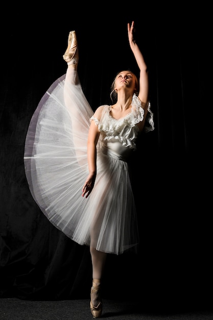 Ballerina in tutu dress posing with leg up