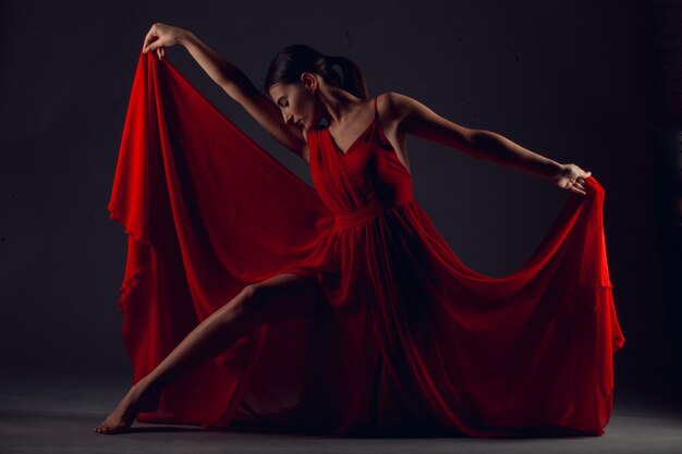 Ballet dancer or classic ballerina dancing isolated on dark background