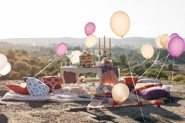 Balloons levitate in the air above white table with candles